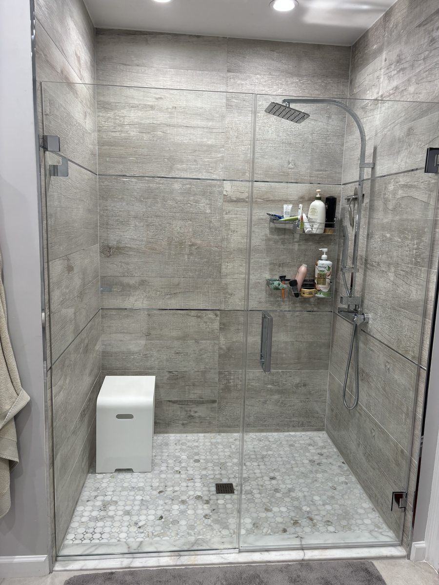 Custom frameless shower enclosure with polished chrome hardware