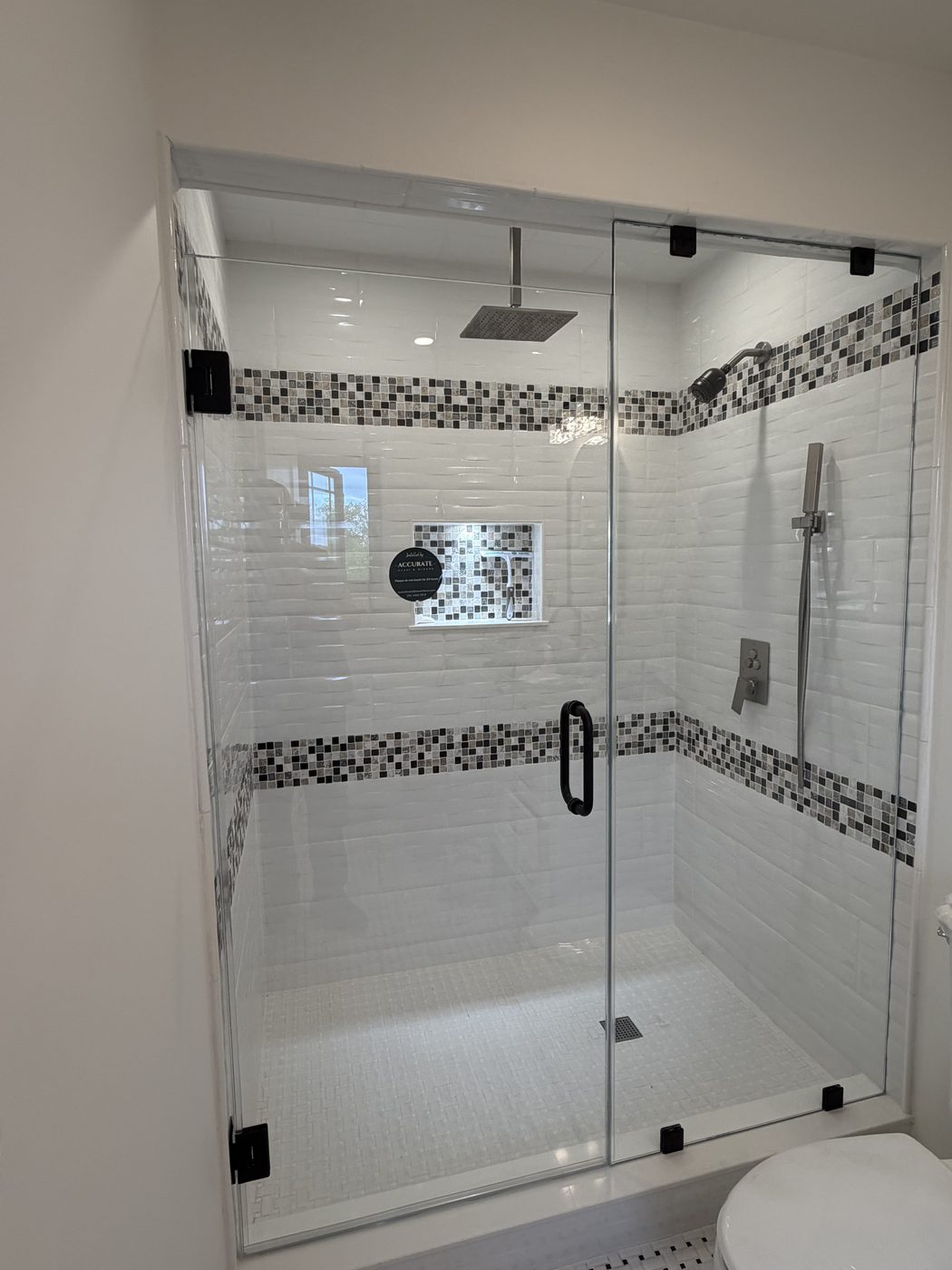 Frameless glass shower with marble walls and rainfall head