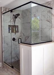 Black-framed glass shower on a tiled half-wall