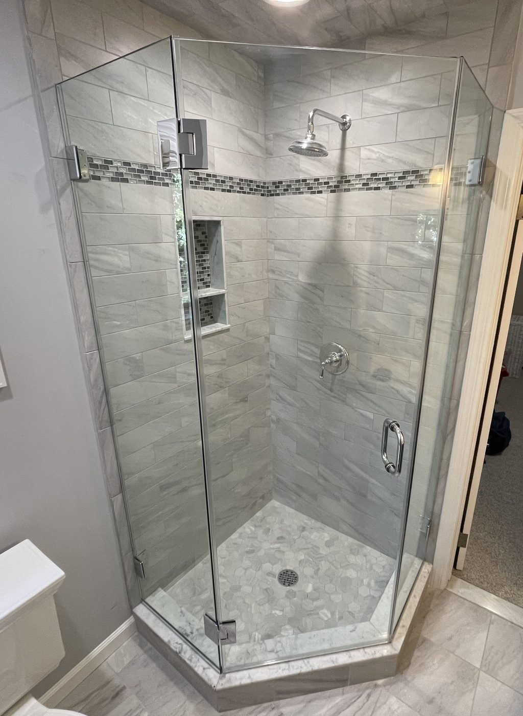 Neo-angle frameless glass shower with marble tile