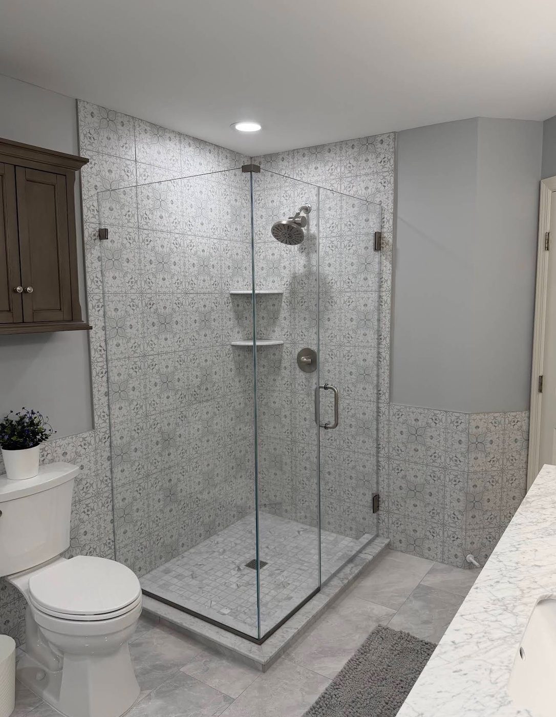 Frameless corner shower with marble and black hardware