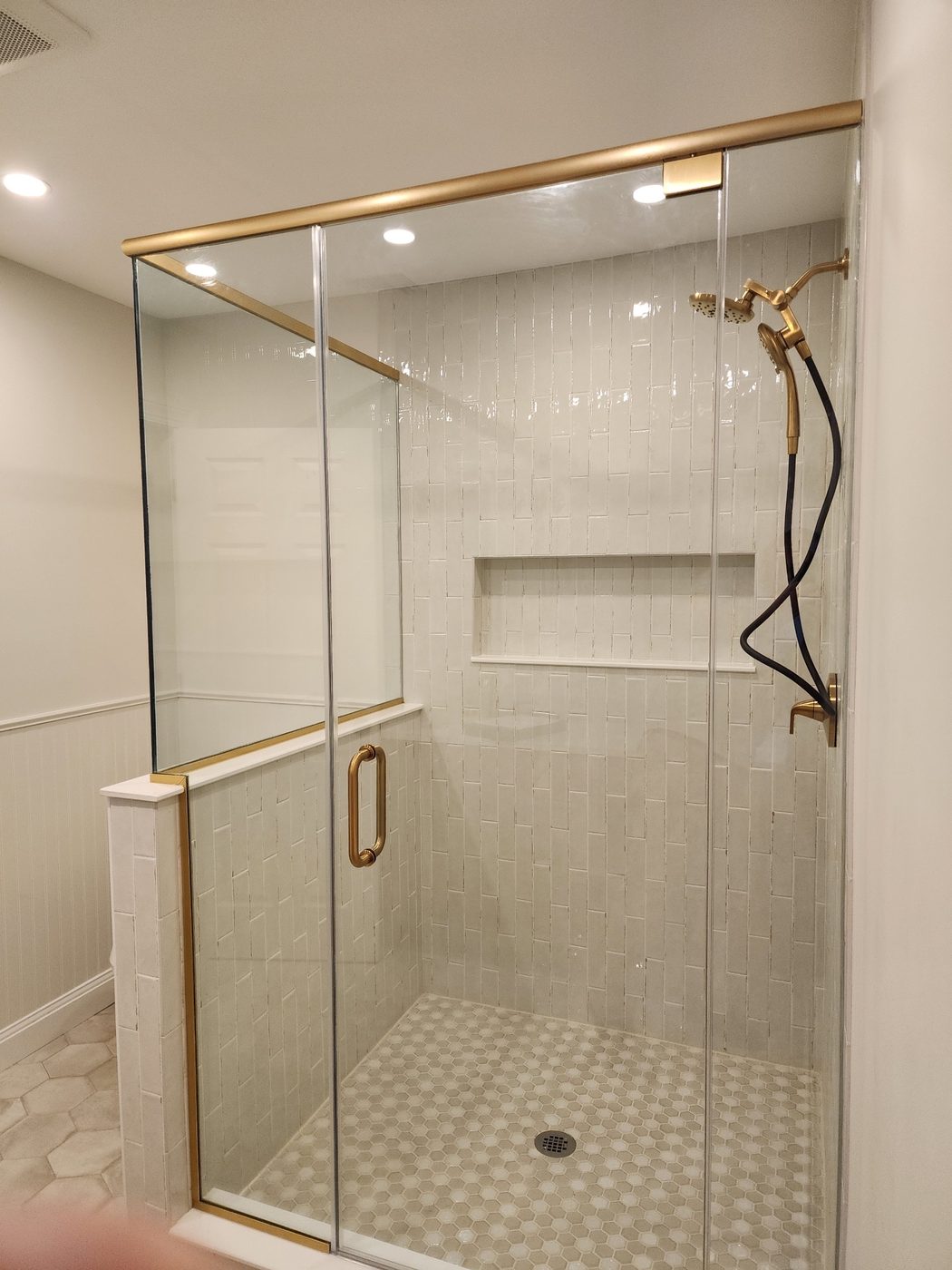 Frameless corner shower enclosure with brass hardware