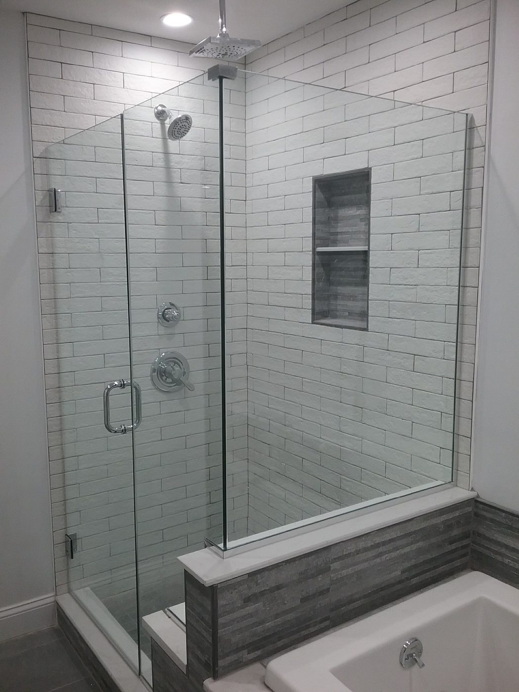 Frameless glass shower with subway tile and accent band