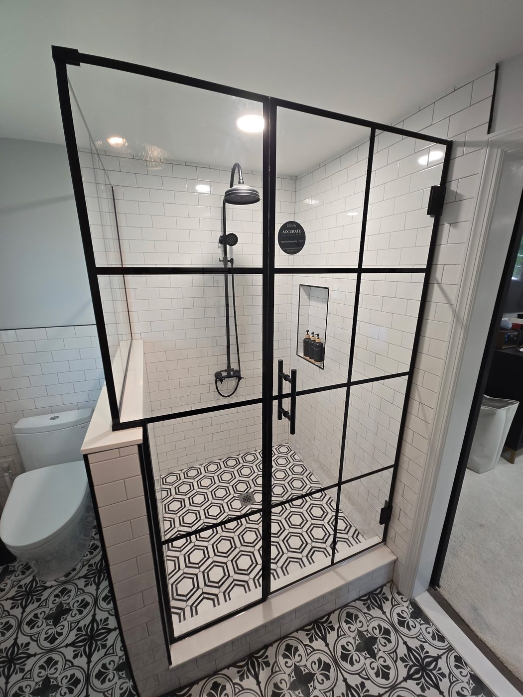 Black-grid framed glass shower over white subway tile