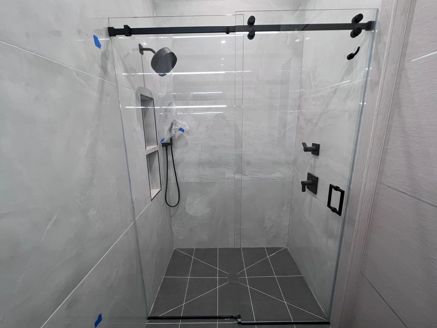 Sliding glass shower door with marble walls