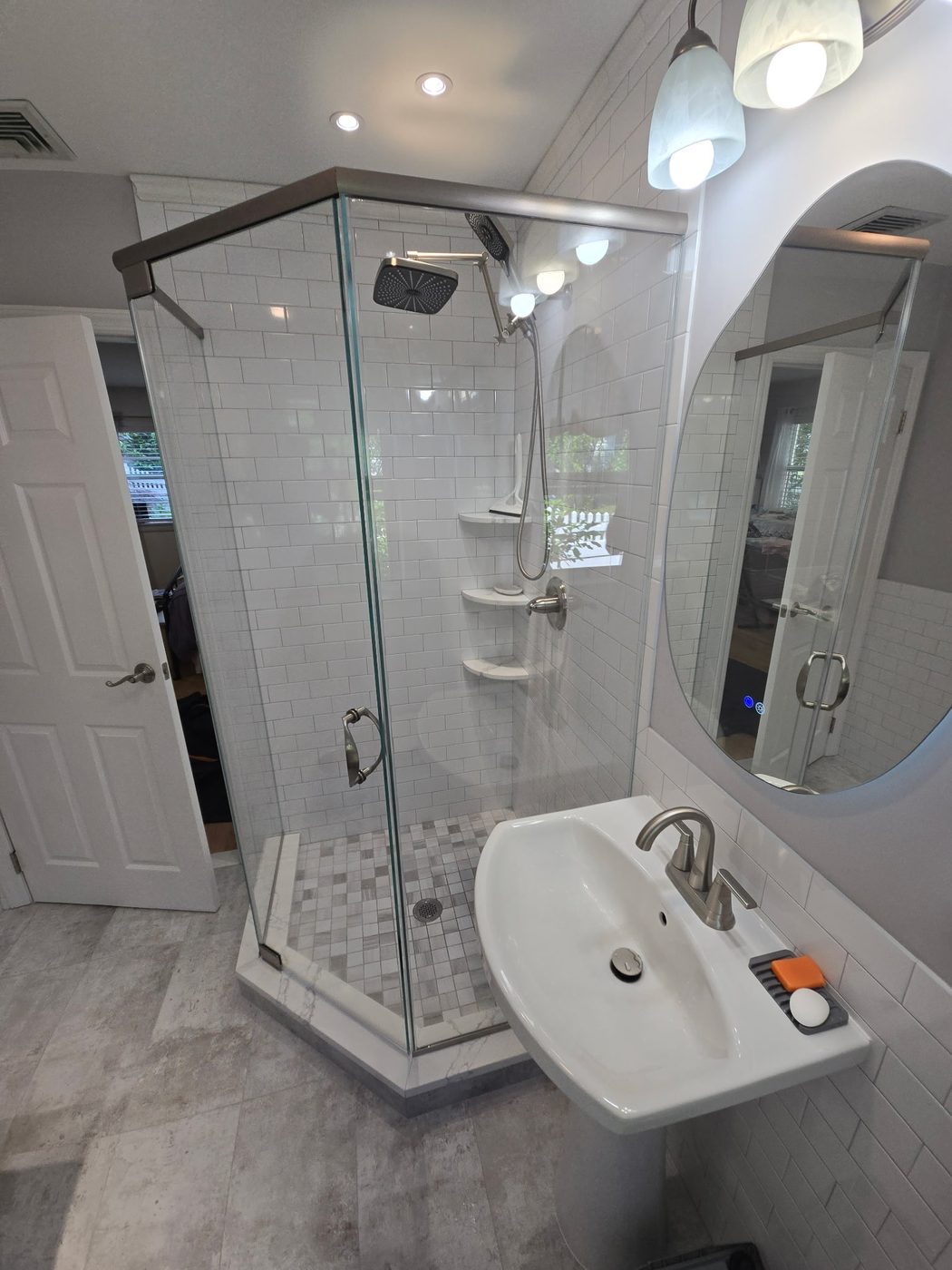 Frameless corner shower with chrome hardware and vanity